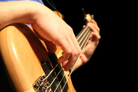 A bass guitar player plucks the strings