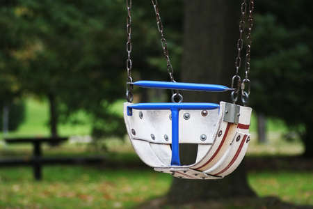 A baby swing in a childrens playgroundの写真素材