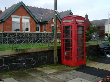 A British Phone booth set on a street in a country townの写真素材