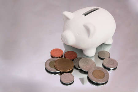 White piggy bank with change Canadian scattered aroundの写真素材