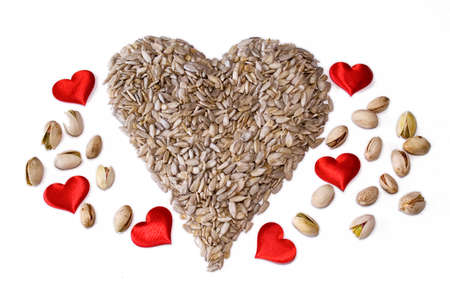 A healthy heart made from sunflower seeds  Shelled  with Pistachios and red heartsの写真素材