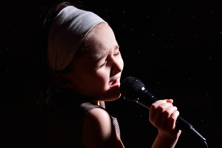 Little cute girl singing on the microphoneの写真素材