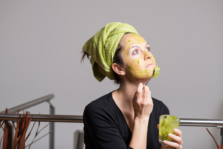Attractive young woman with spots using a facial avocado maskの写真素材