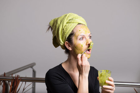 Attractive young woman with spots using a facial avocado mask