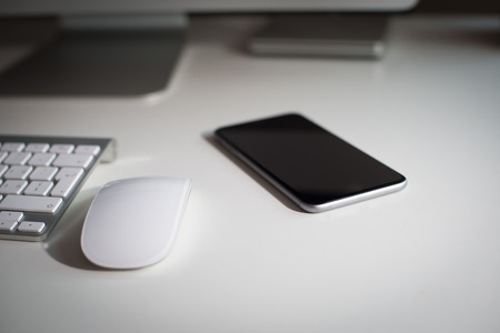 Desktop monitor with a wireless keyboard mouse dvd drive and a smartphoneの写真素材