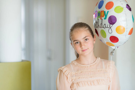 Lovely blonde girl with a ballon have fun by her birthday