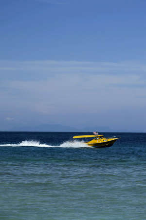 A boat navigates across the blue sea at Pulau Perhentian.の素材