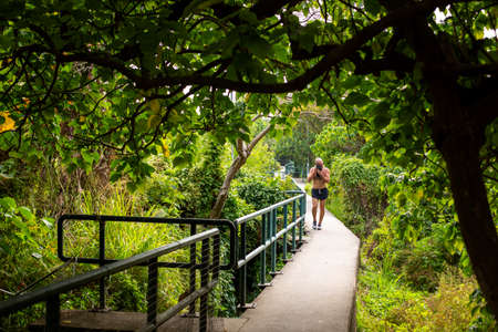 A man is seen jogging on a track surrounded by trees in Lamma Island, Hong Kongのeditorial素材
