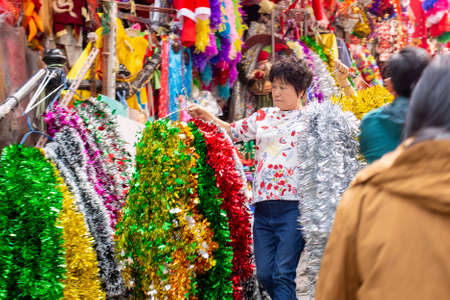 A woman arranges decoration items for Christmas in Hong Kongのeditorial素材