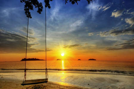 Swing on paradise sunset on the beach.の写真素材