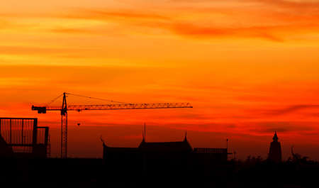 Industrial construction cranes and building at sunriseの写真素材
