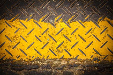 Dark steel floor plate paint with yellow patternの写真素材