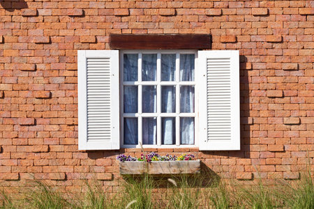Vintage white window on red brick wallの写真素材
