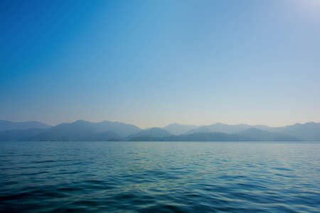 Simple sea and mountain, Blue Sea and shade of mountain as defocused on sea. And nothing on sea. no people on sea.の写真素材