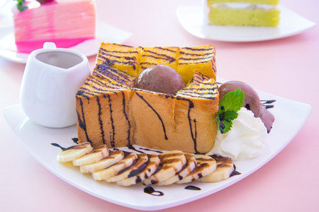 honey toast banana and chocolate on pink table