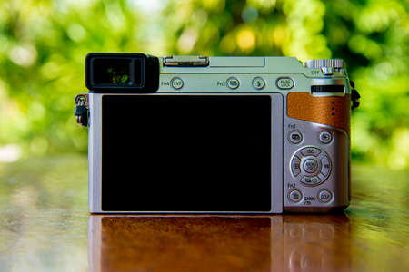 Black LCD behind camera on wooden tableの写真素材