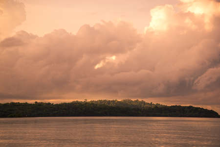 Orange sky at a sunset and island litted by sunの写真素材
