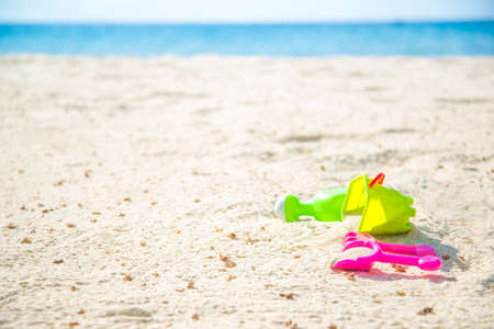 Children's beach toys - buckets, spade and shovel on sand on a sunny dayの写真素材