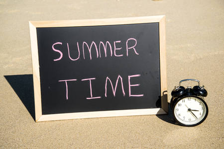 Summer time on black board on tropical beach background.の写真素材