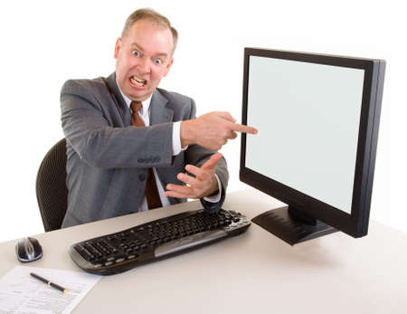 Angry middle aged businessman is pointing to the monnitorの写真素材