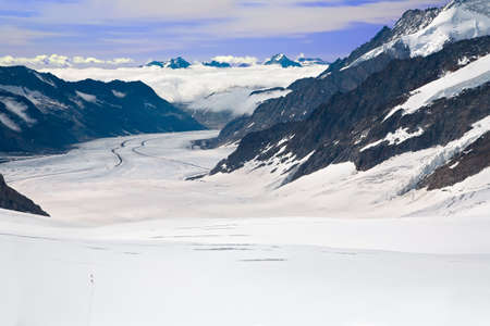 Two Hikers Walking Towards the Aletsch Glacier in the Alps, Switzerlandの写真素材