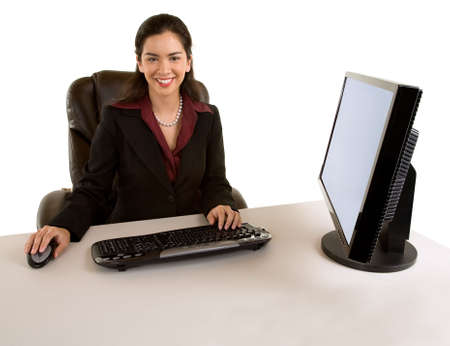 Businesswoman Sitting at her Desk and Smiling at the Cameraの写真素材