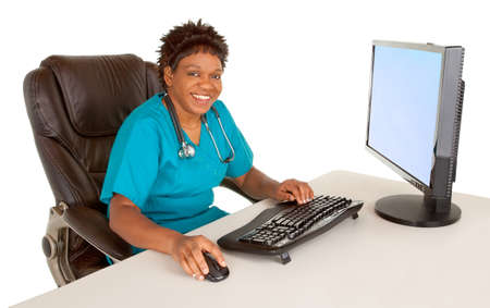 Smiling African American Nurse Looking at Camera While Sitting at her Deskの写真素材
