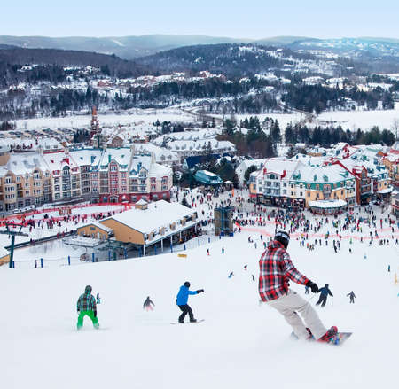 Mont-Tremblant, Canada - February 9, 2014  Skiers and snowboarders are sliding down the main slope at Mont-Tremblant  Mont-Tremblant Ski Resort is acknowledged by most industry experts as being the best ski resort in Eastern North America のeditorial素材
