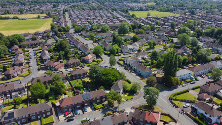 Aerial view of a suburban neighborhood showcasing houses, streets, and green spaces during a clear dayの写真素材