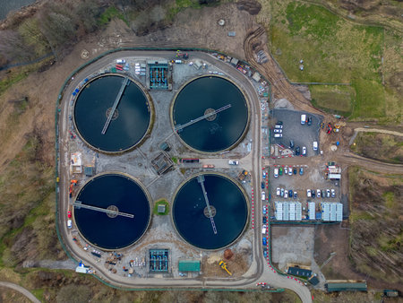Overview of a wastewater treatment facility showcasing circular tanks and surrounding infrastructure