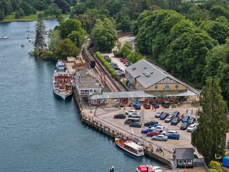 Scenic waterfront view of a bustling marina with boats and vehicles during a sunny dayの写真素材