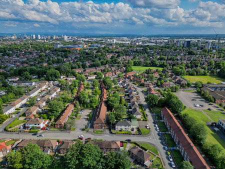 Urban landscape view showcasing residential areas and city skyline in the background with scattered cloudsの写真素材