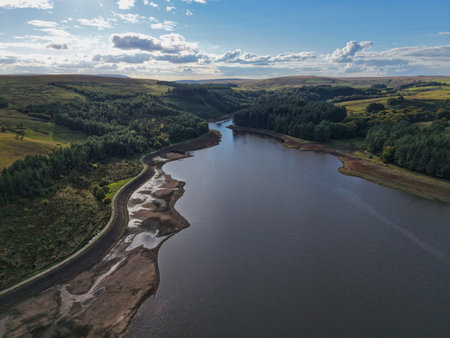 Scenic view of a winding river surrounded by lush greenery and blue skies in a countryside landscapeの写真素材
