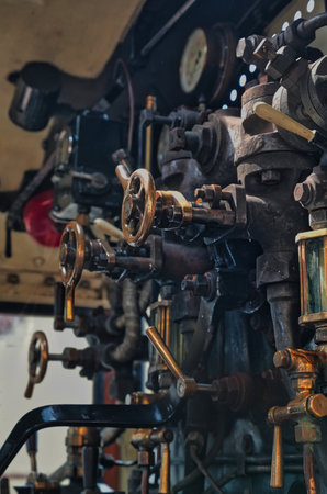 Detailed view of vintage machinery valves and levers in an old factory workshop settingの写真素材