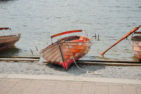 Colorful wooden boats resting by the water on a sunny day near a peaceful shoreの写真素材