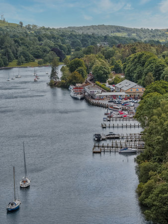 Scenic view of a river with boats and a charming lakeside village surrounded by greeneryの写真素材