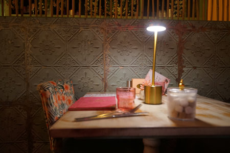 Cozy dining table setting with warm lighting at a stylish restaurant in the eveningの写真素材