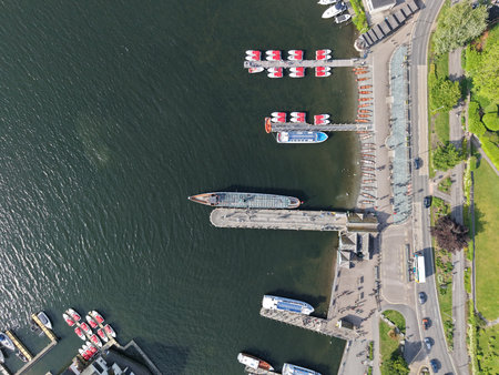 Birds eye view of a busy marina with boats docked and people enjoying leisure time by the waterの写真素材