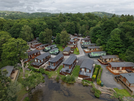 Cabins nestled among trees near a lake in a serene holiday park in the countrysideの写真素材