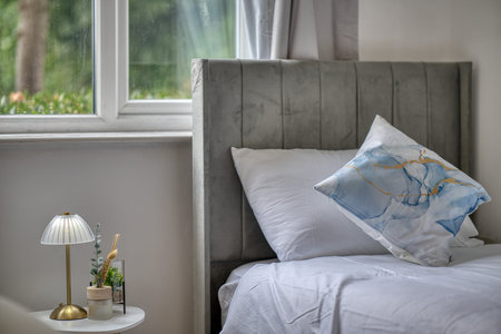 Cozy bedroom with soft lighting and modern decor overlooking a peaceful garden in the daytime