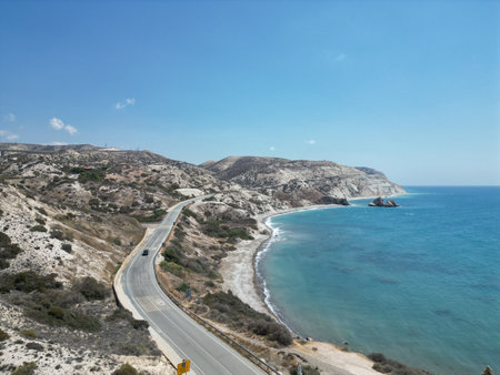 Scenic coastal road along the blue sea with cliffs under bright skyの写真素材