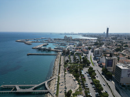 Scenic coastal view of a bustling harbor with boats and vibrant city life during a sunny dayの写真素材