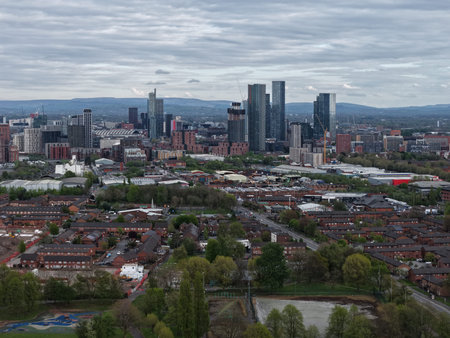 Sky view capturing a bustling urban landscape of Manchester with modern buildings and green spaces belowの写真素材