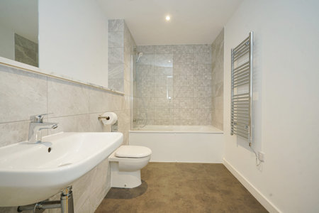 Modern bathroom design featuring a shower and tub combination with sleek fixtures and neutral colors