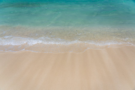 Turquoise waves washing up on a white sand beach