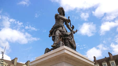 Historic and beautiful statue of Joan of Arc in pose of fighting against a blue sky and white cloudsのeditorial素材