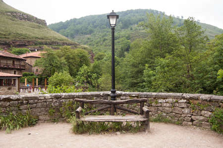 seat of wood in the forest with a lamppostの写真素材
