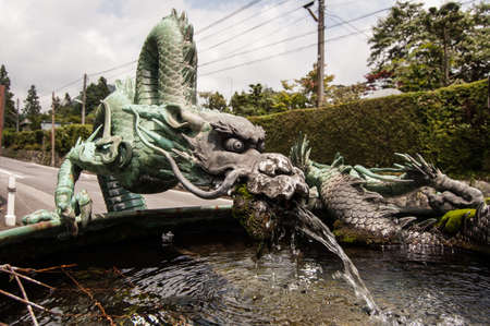 Metallic sculpture of a dragoon in a fountain in japanの写真素材