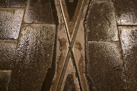 Crossed railway tracks in the city with wet grey floor backgroundの写真素材