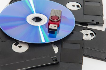 Red usb drive put on cd and have disket under them.(Selective focus.)の写真素材
